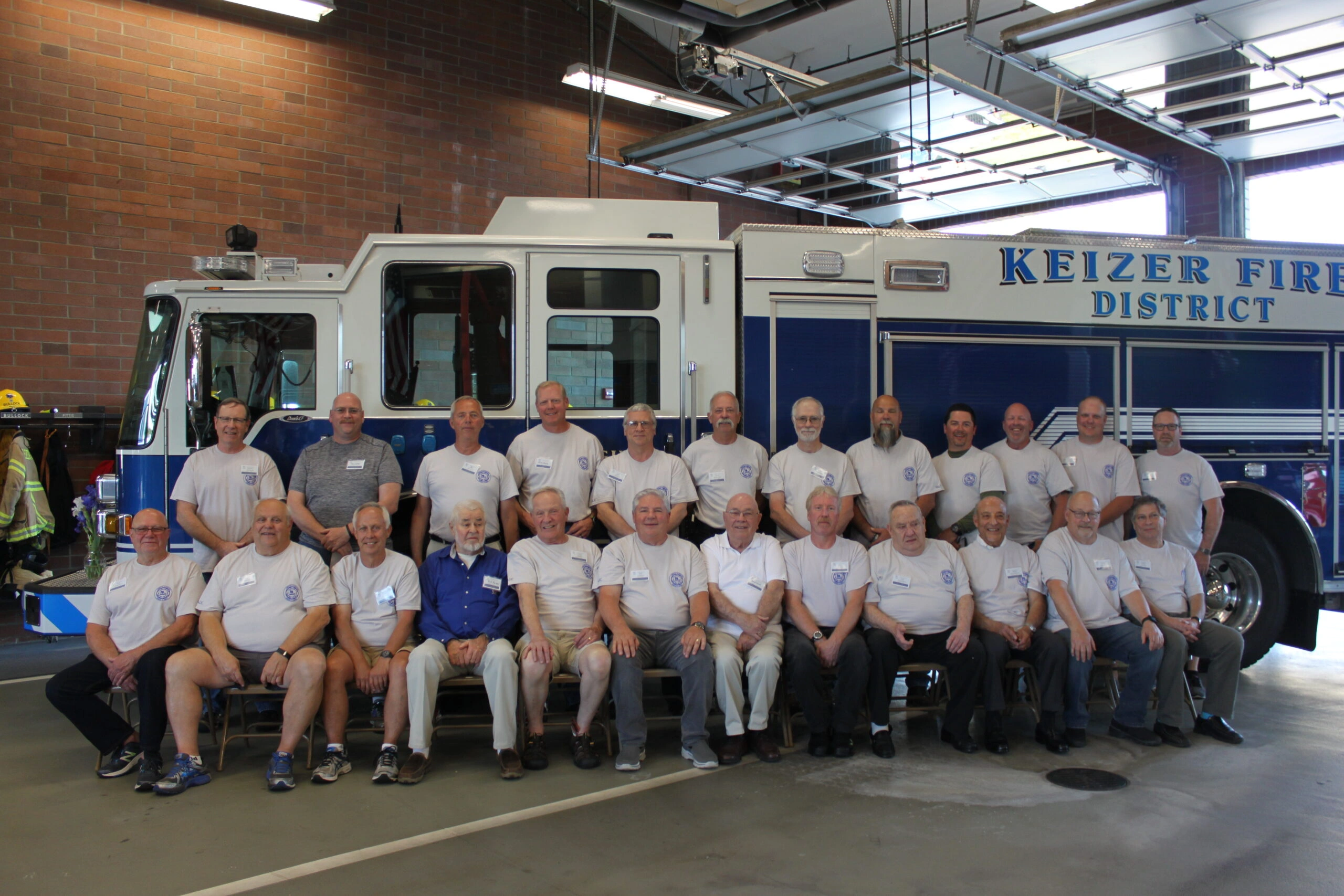Members of the Keizer Fire District posing for a photo in front of a blue fire engine